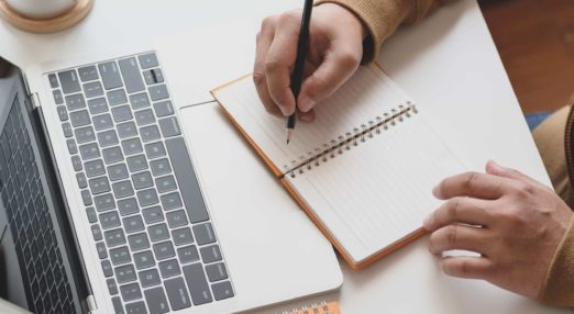 person writing in notebook