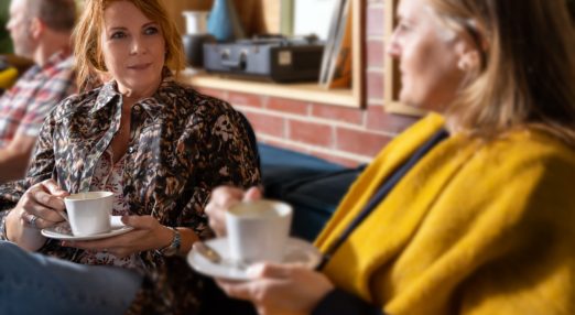 Women on sofa drinking coffee