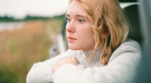 young blonde woman looking out of car window