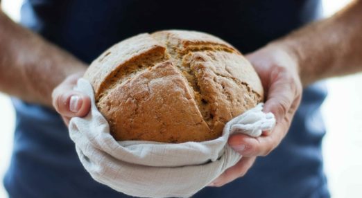Hands holding a loaf of bread