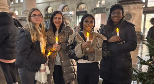 Four women hold candles