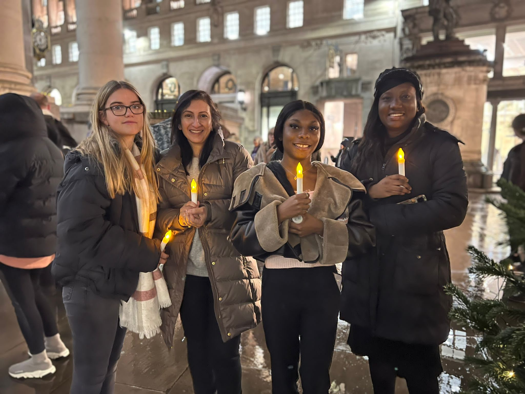 Four women hold candles